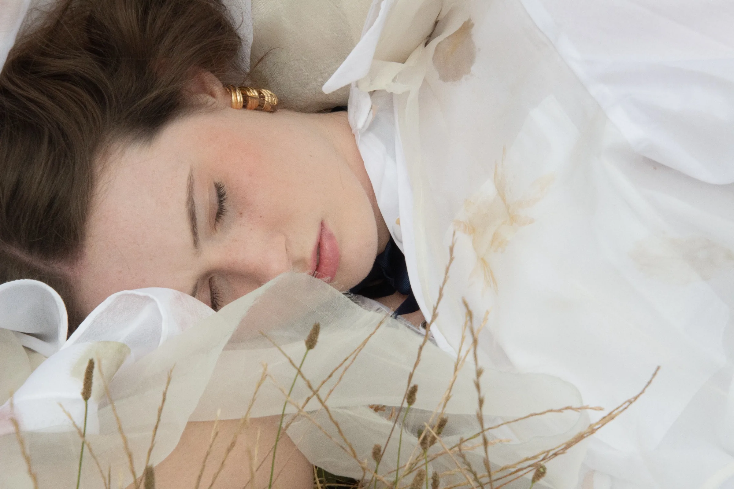 A sleeping model in soft focus, gold earring catching the afternoon