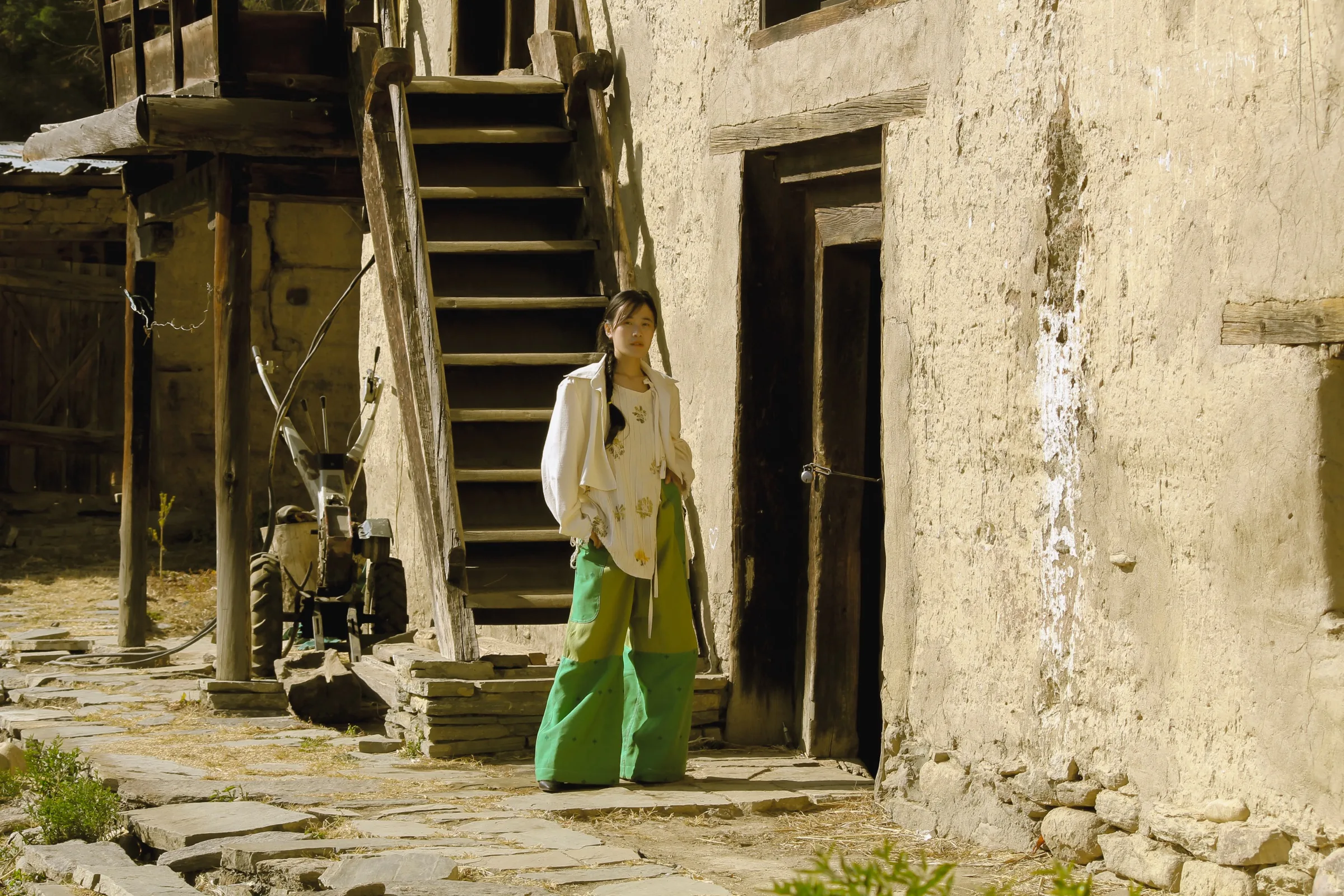 The eco-printed jacket and green trousers, walking through the village