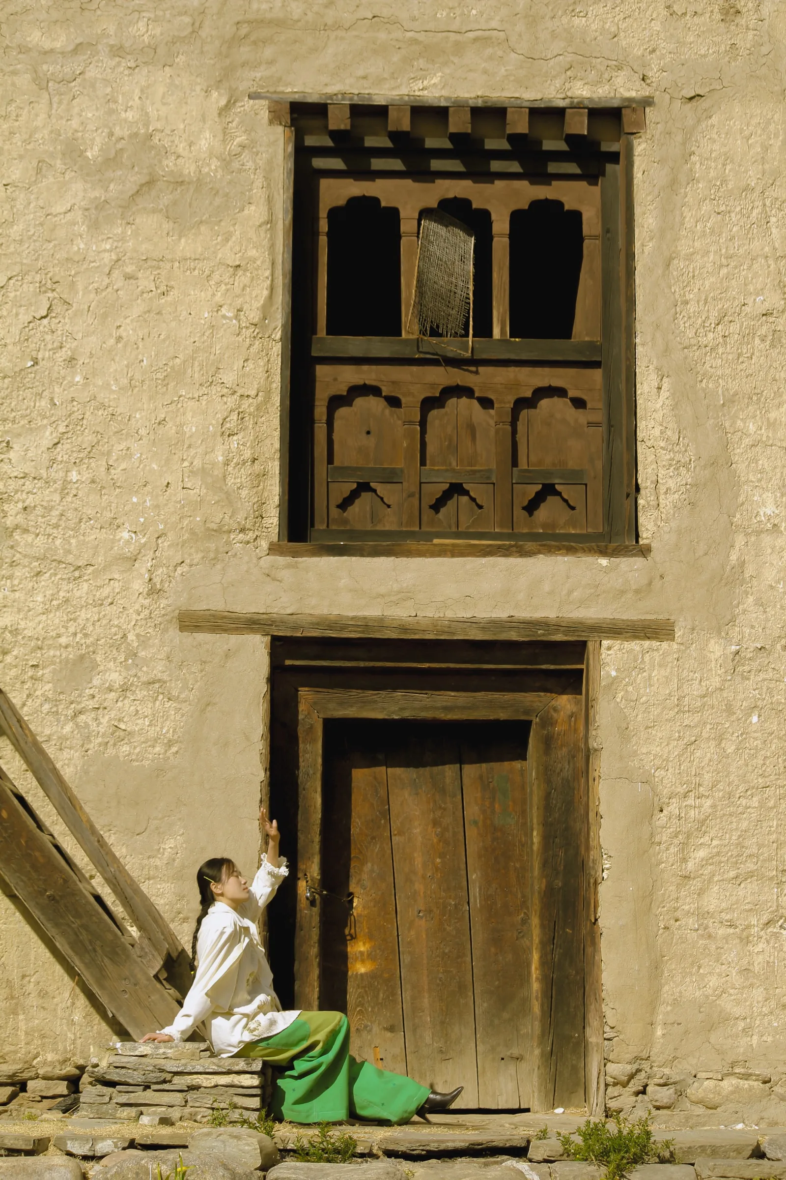 Seated beneath a carved Bhutanese window in the eco-print look