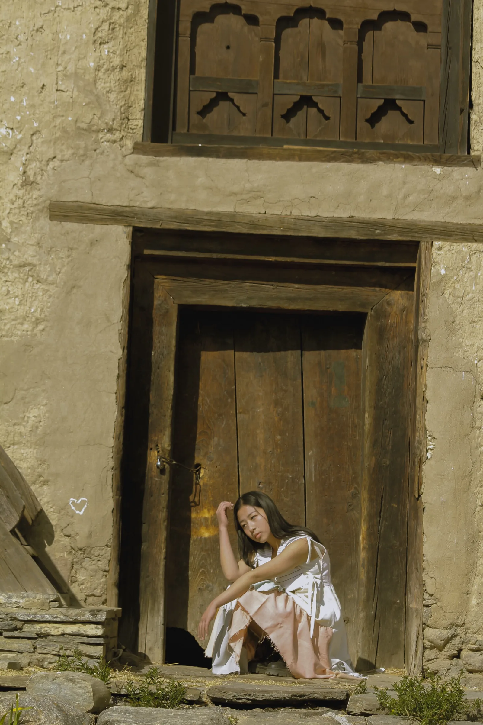 Seated in a doorway in the dyed dress