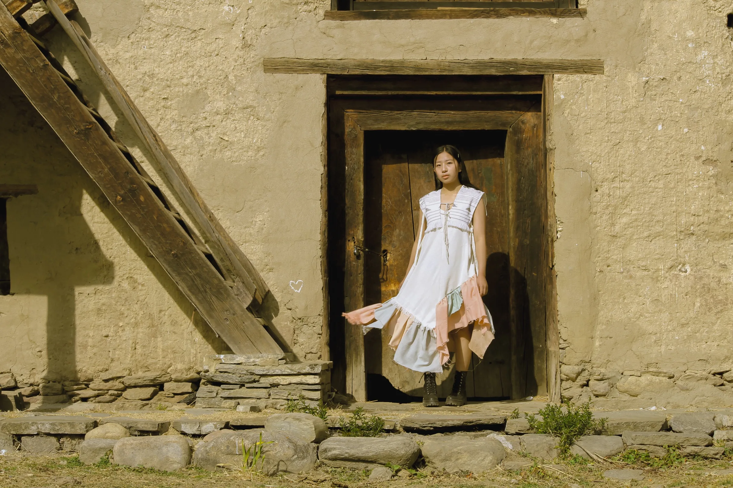The dress framed by a rammed-earth doorway