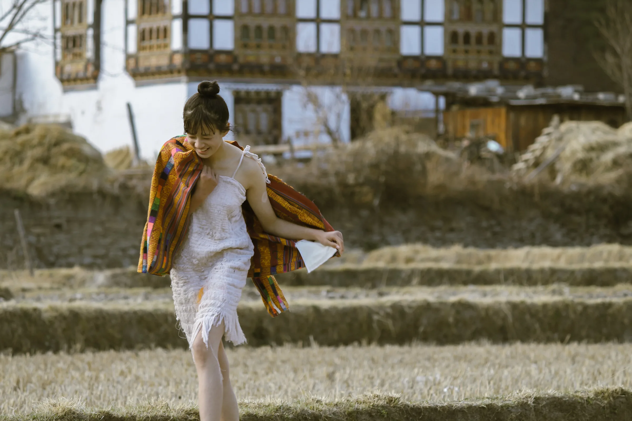 Carrying the remade jacket across the field, the village behind