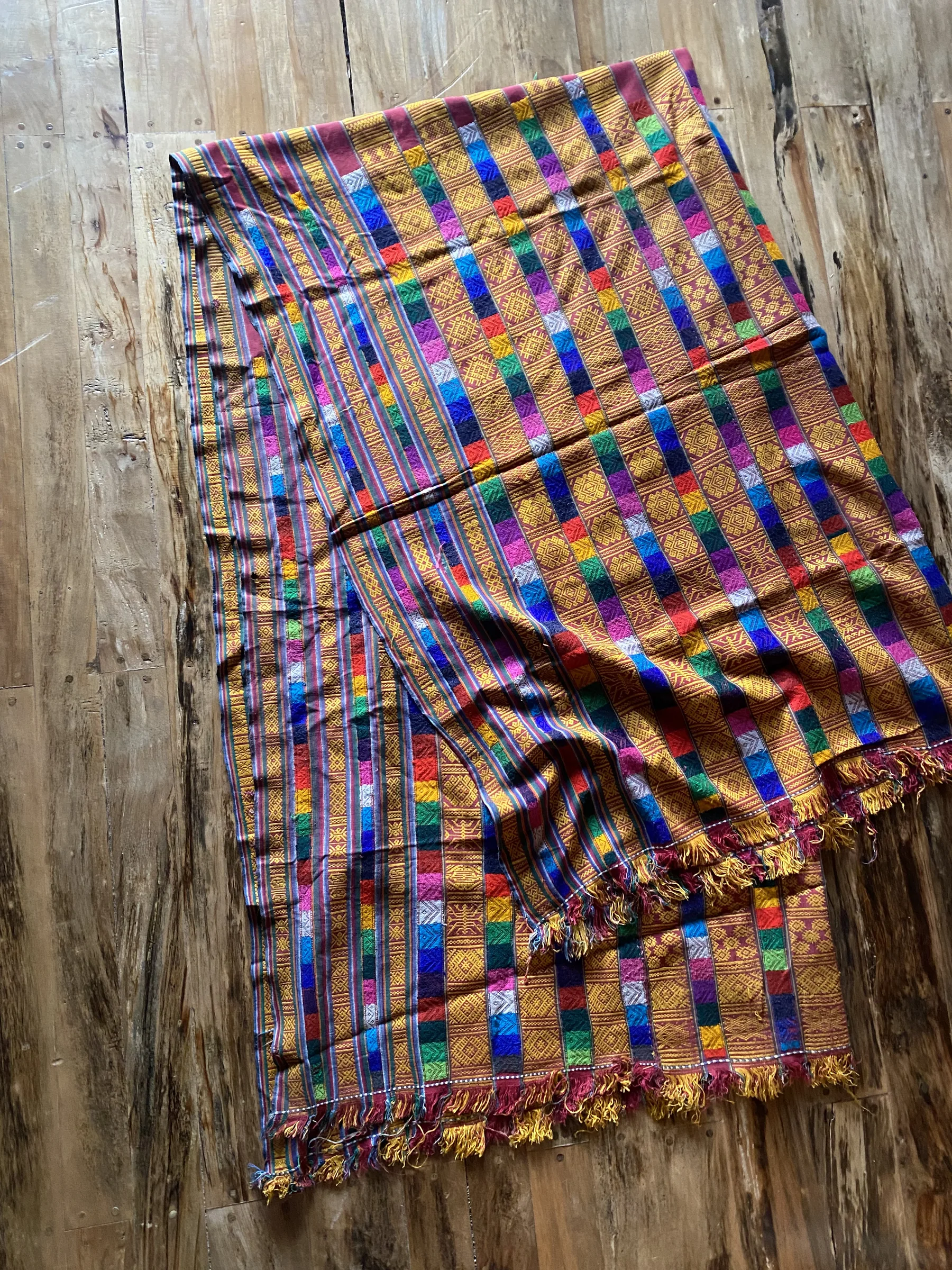 The old handwoven Bhutanese textile, fringed and worn, before it was remade