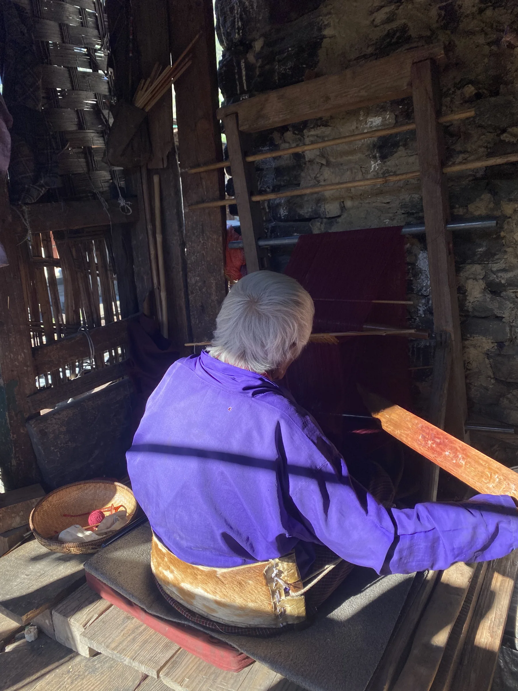 Sither Lhamo at her back-strap loom, afternoon light